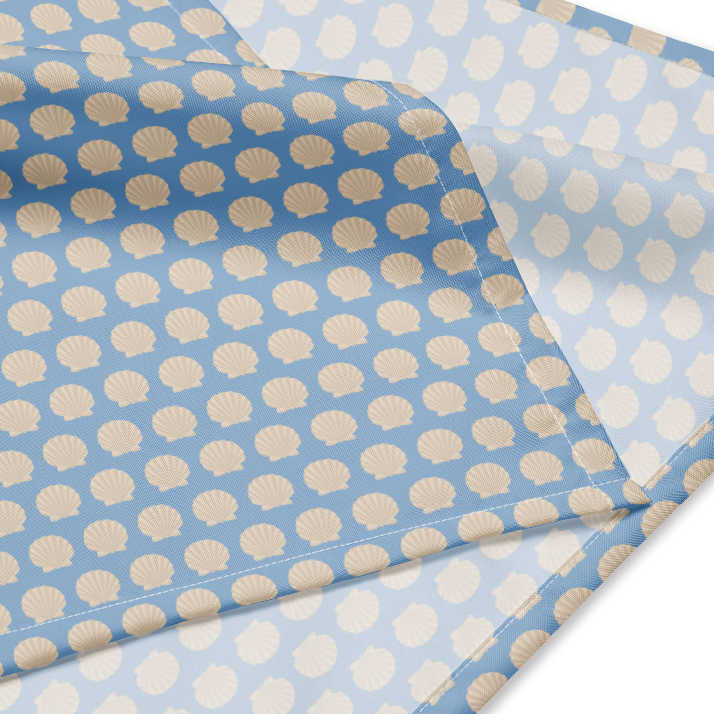 Multifunktionales Camino Bandana in Hellblau mit stilisiertem Jakobsmuschel-Print. Ideal für Wanderer und Pilger auf dem Jakobsweg.